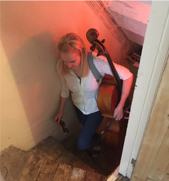Belinda carrying cello upstairs